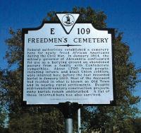 Freedmen's Cemetery Historical Site Marker - E 109 Freedmen's Cemetery - Federal authorities established a cemetery here for newly freed African Americans during the Civil War. In January 1864, the military governor of Alexandria confiscated for use as a burying ground an abandoned pasture from a family with Confederate sympathies. About 1,700 freed people, including infants and black Union soldiers, were interred here before the last recorded burial in January 1869. Most of the deceased had resided in what is known as Old Town and in nearby rurual settlements. Despite mid-twentieth-century construction projects, many burials remain undisturbed. A list of those interred here has also survived.